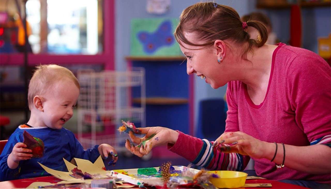 Woman and young boy enjoying some messy play