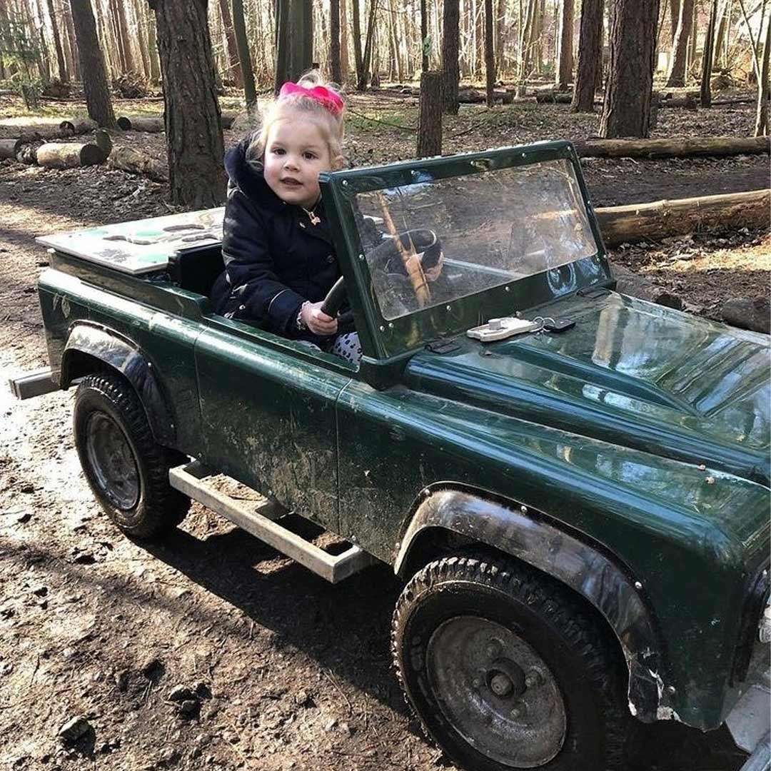 Young girl in a small car.