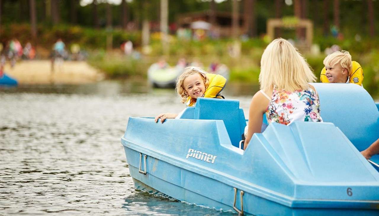 Family sitting in a Pedalo on the lake