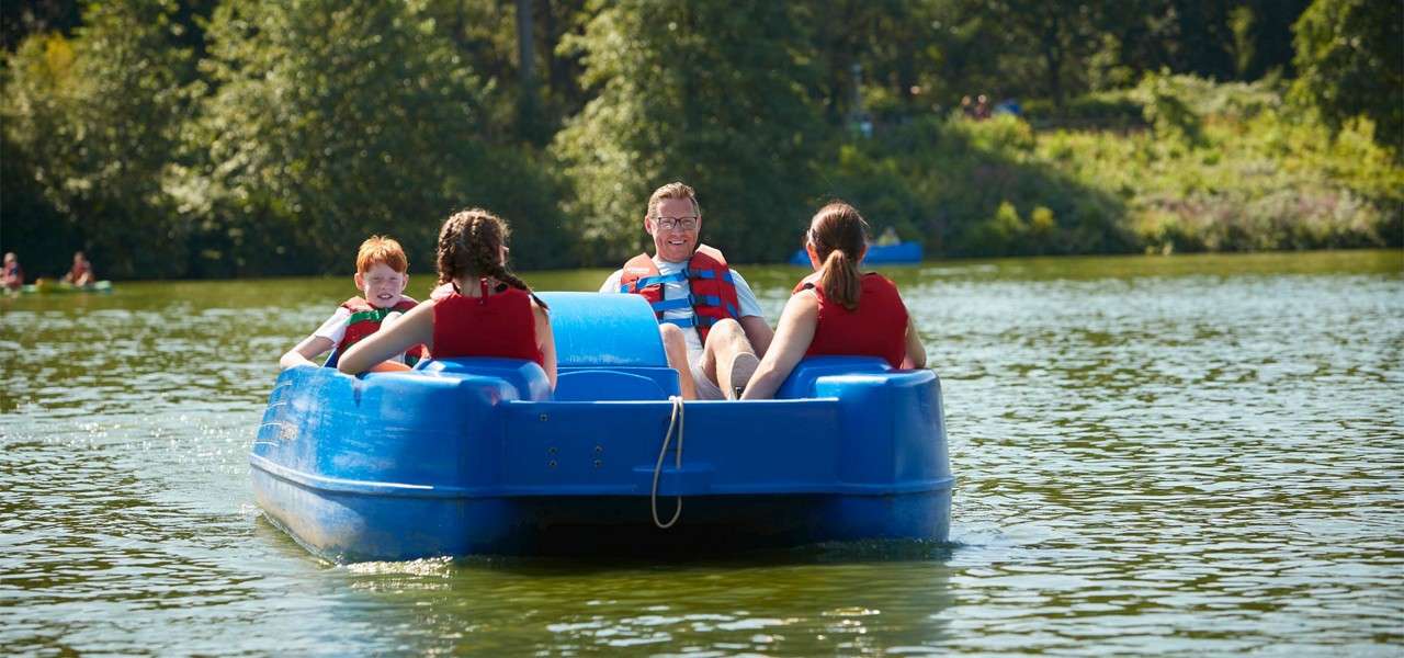 Family sitting in a Pedalo on the lake