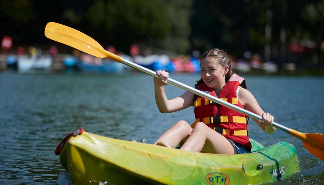 Young girl on a Single Kayak floating on the lake.