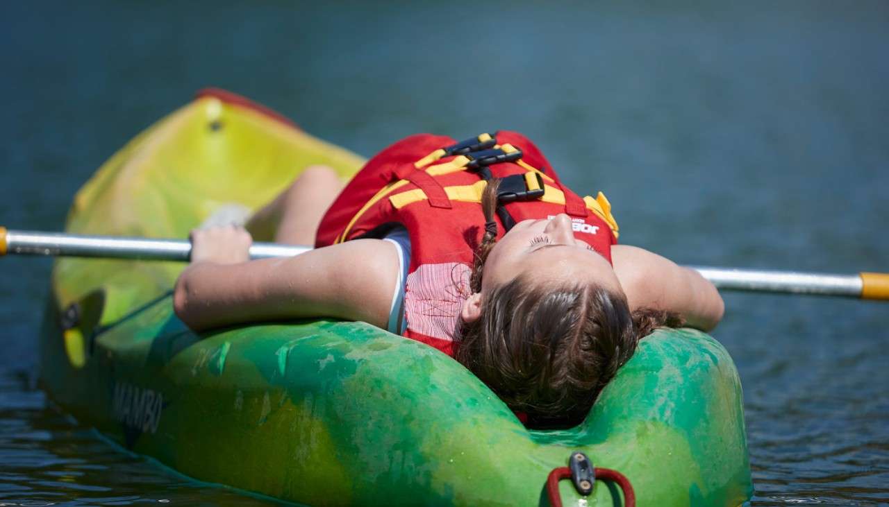 Young girl laying back on a Single Kayak.