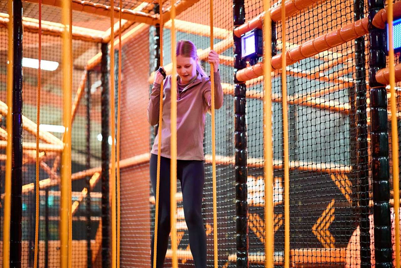 Young girl tackling a rope obstacle.