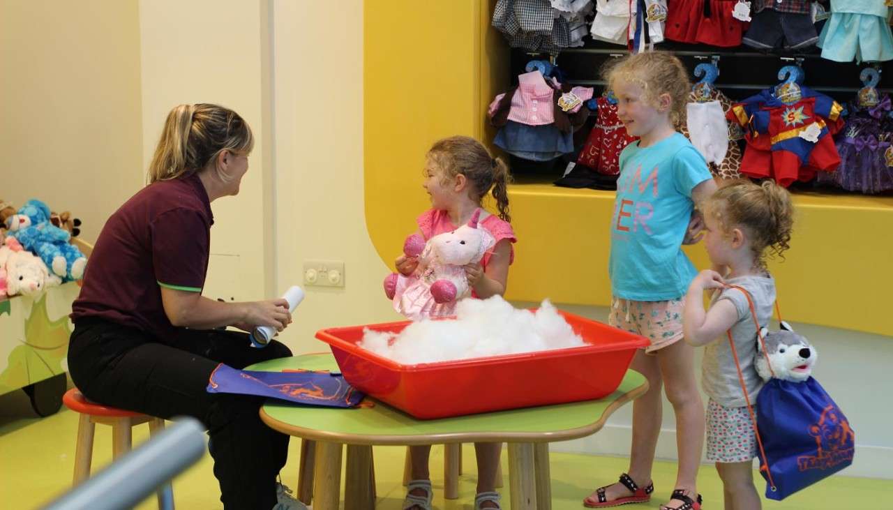 A group of young children stuffing teddy bears.