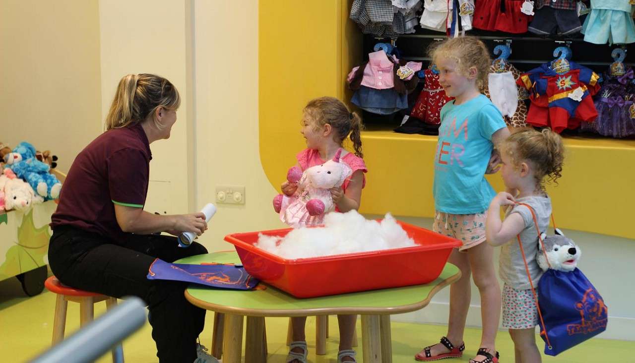 A group of young children stuffing teddy bears.
