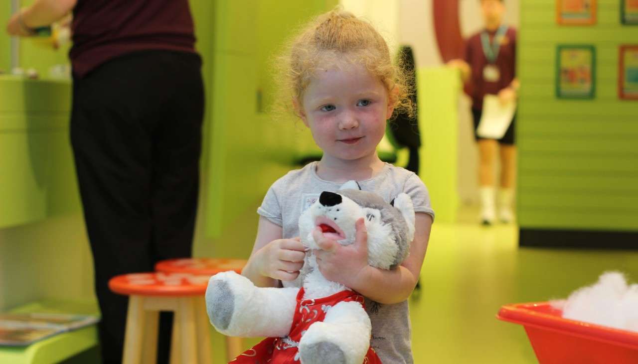 Young girl holding her newly created teddy bear.