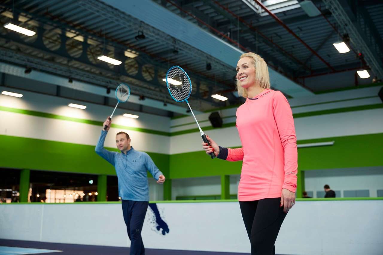 Two adults with their rackets in the air