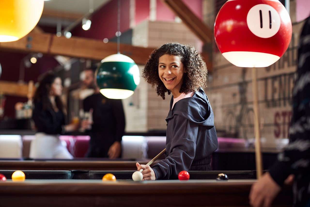 A girl aiming her pool cue 