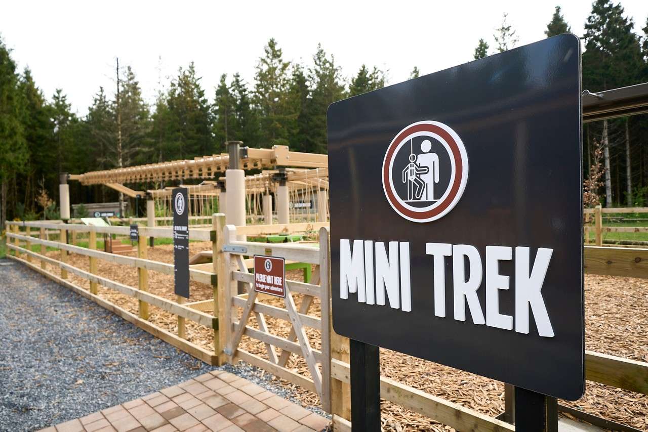 'Mini Trek' sign in front of a wooden obstical course.