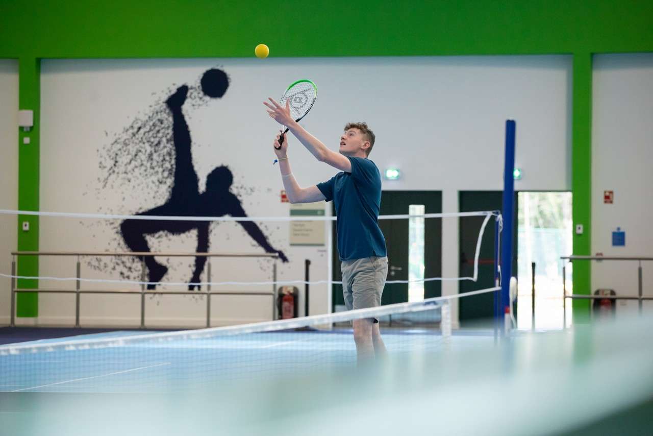 A teen ready to serve the ball