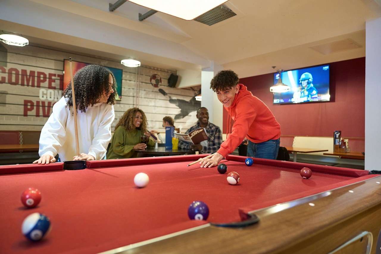 A boy aiming his shot in pool