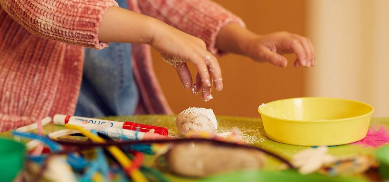 Young girl getting creative with a variety of craft items.