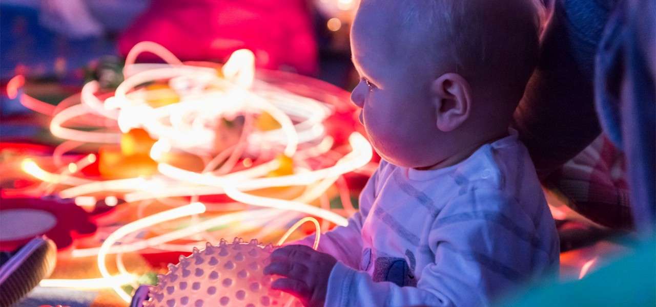 Baby playing with textured, glowing toys.