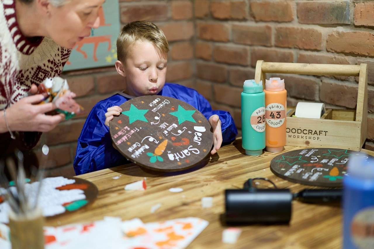 Young boy drying his painting.