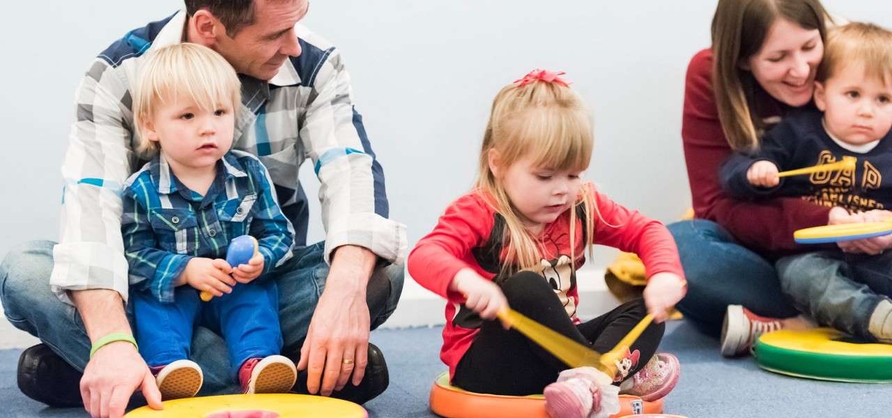 Young children having fun as they make music.
