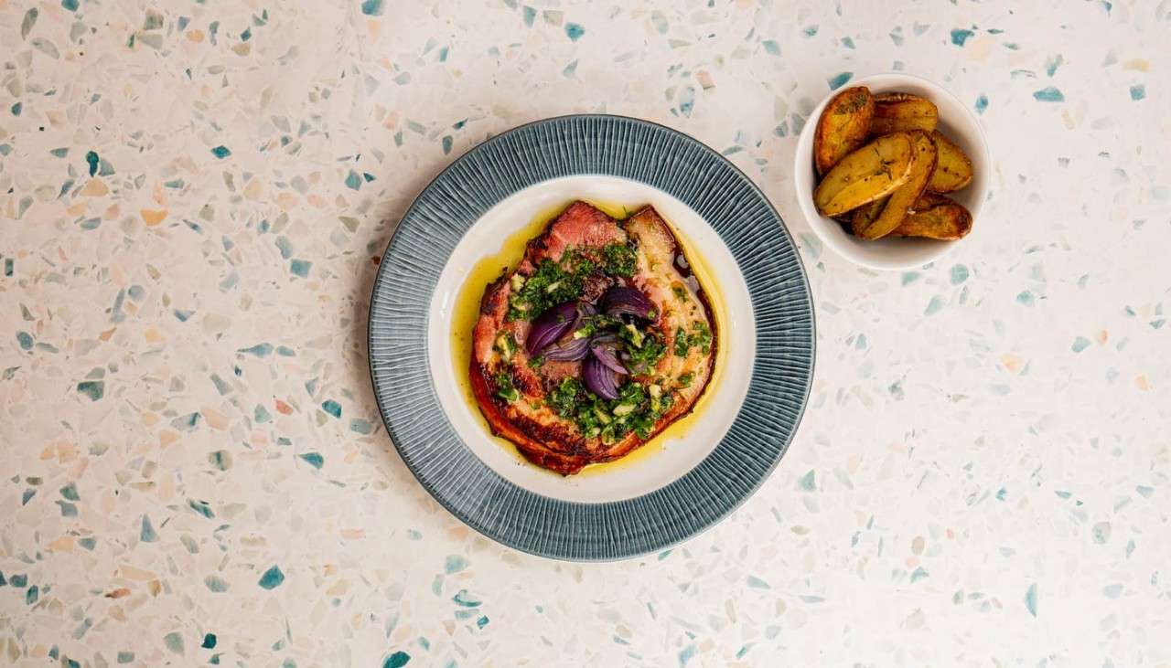 A plate of Porchetta served with thyme-roasted potatoes