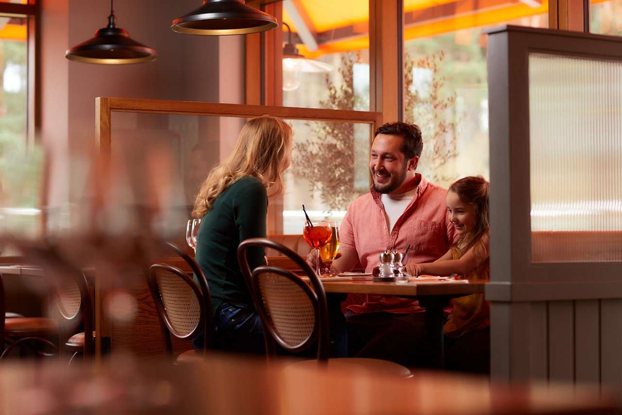 Family sitting in a booth of a restaurant. 