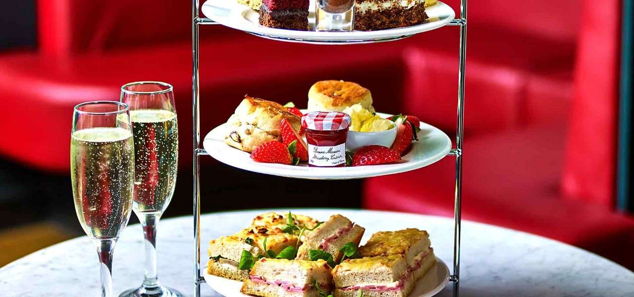 Afternoon Tea platter stacked with sweet and savoury treats.