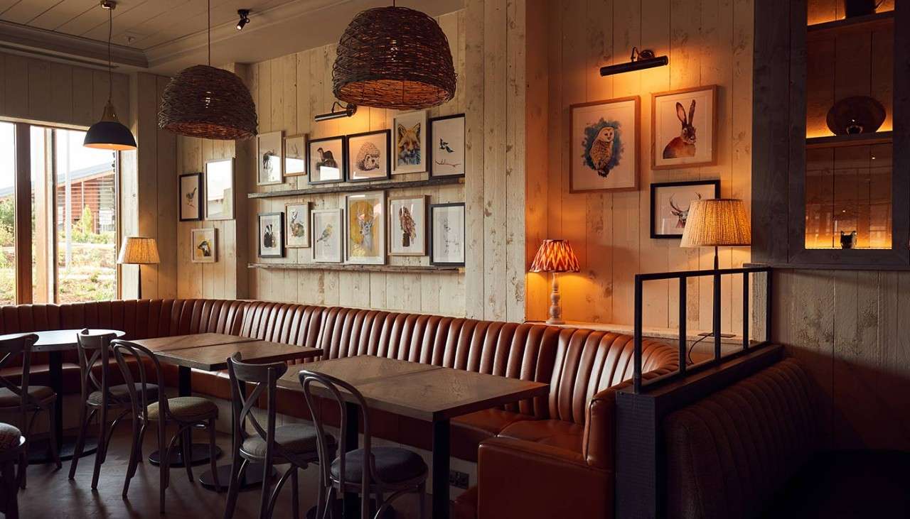 Corner of Cara's with family seating area, and framed illustrations on the walls