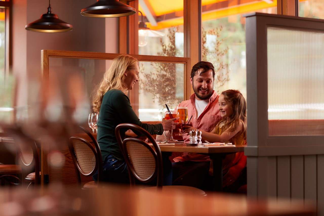 Young girl sitting at a table with her family.