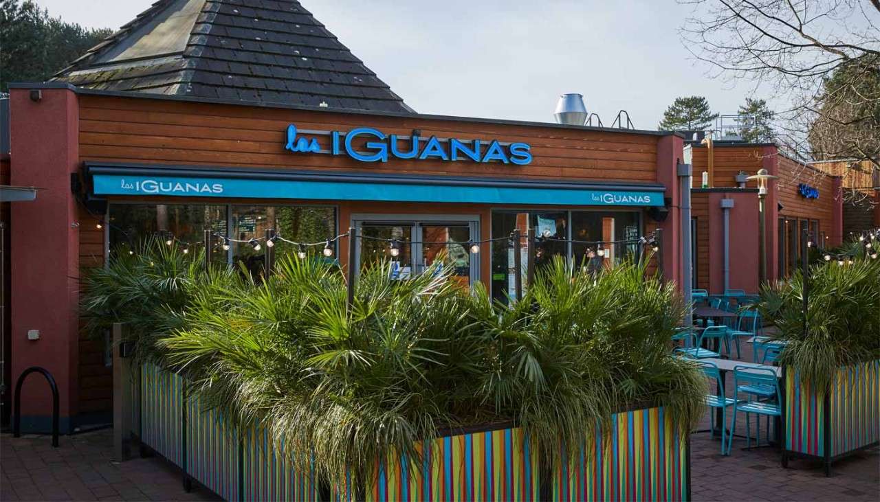 Exterior of Las Iguanas surrounded by bushes
