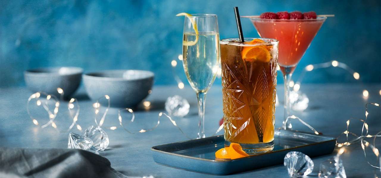 Colourful cocktails against a background with fairy lights.
