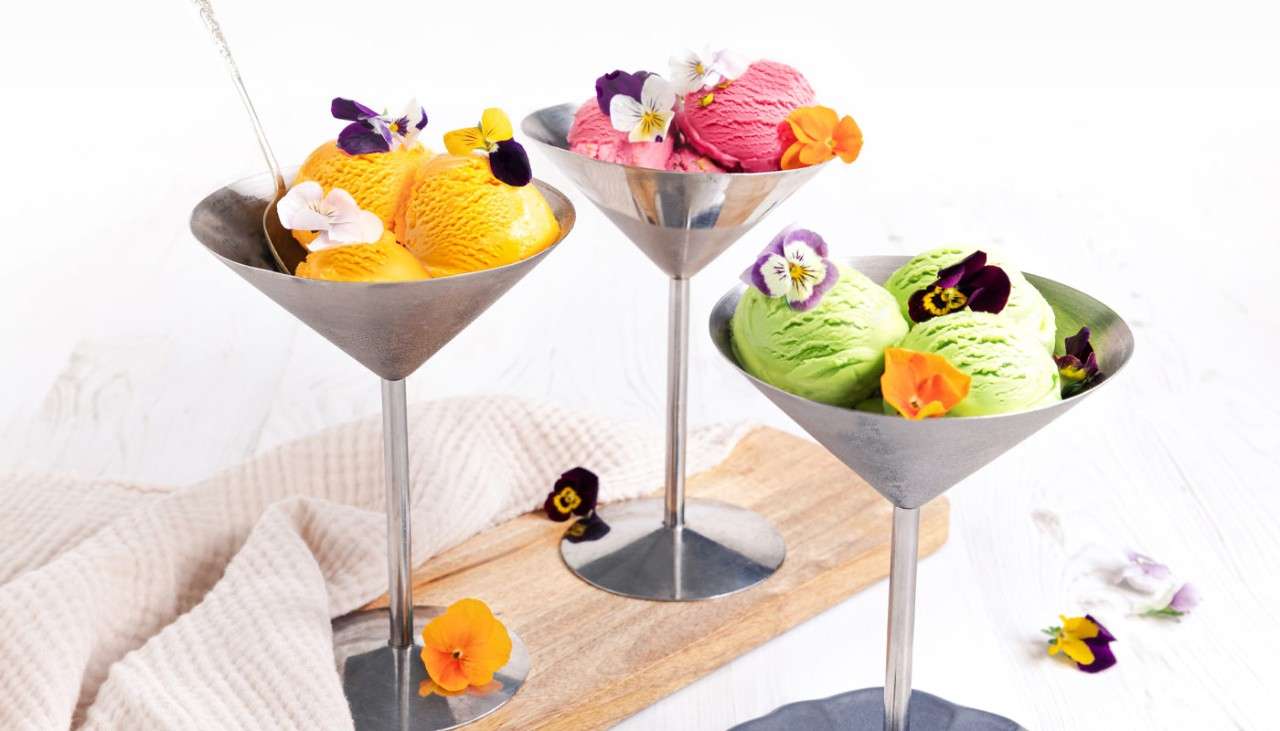 Three kulfi flavours topped with edible flowers.