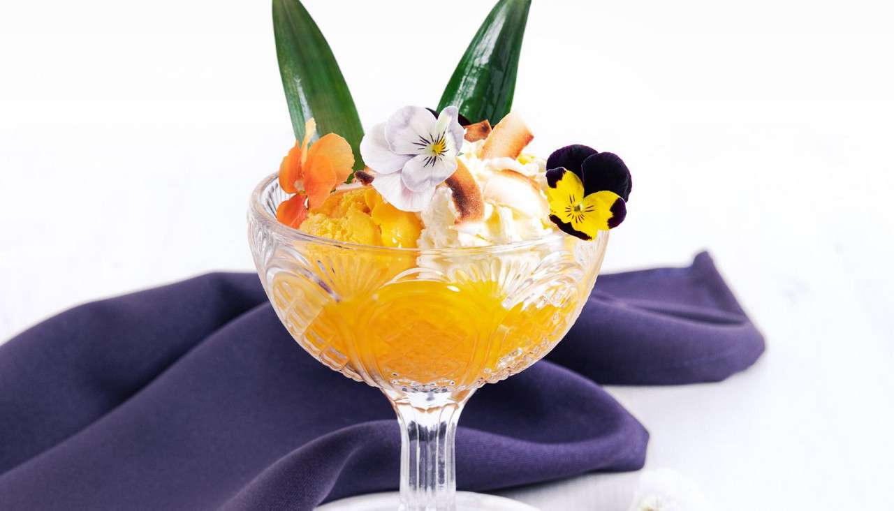 Tropical dessert topped with edible flowers.