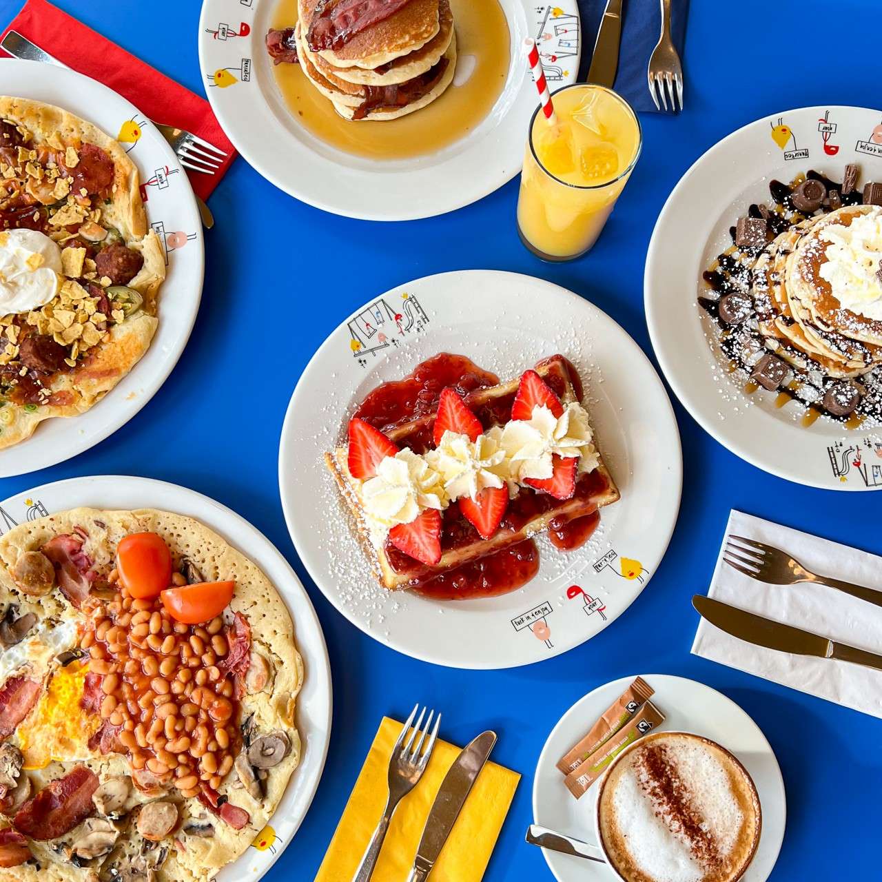 A selection of dishes from The Pancake House menu, including waffles, omelettes and pancake stacks.