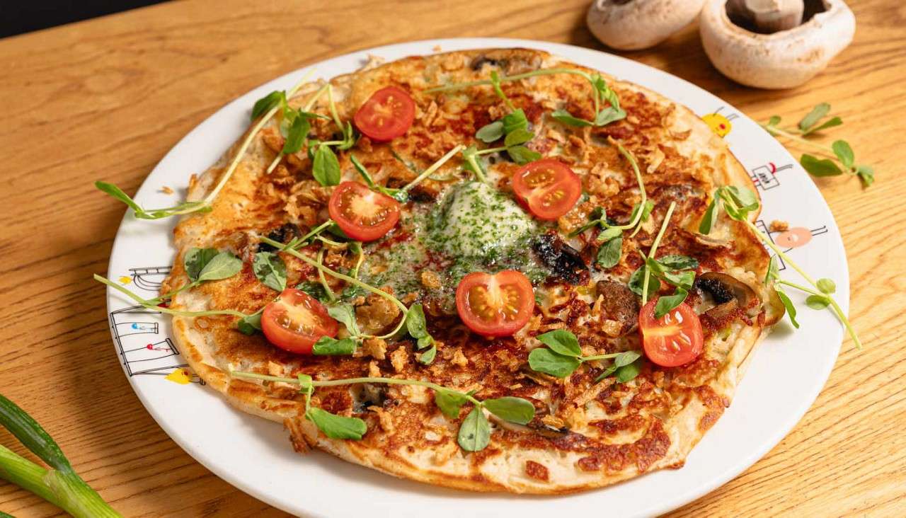 Omelette topped with fresh vegetables.