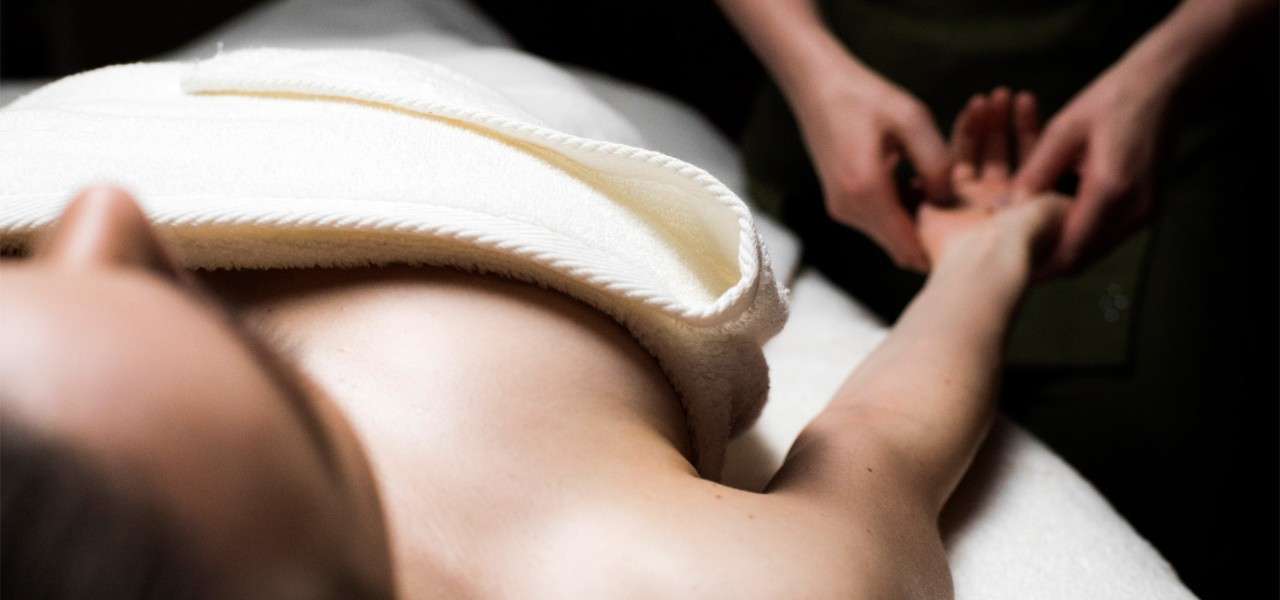 Woman laying having her hand massaged 