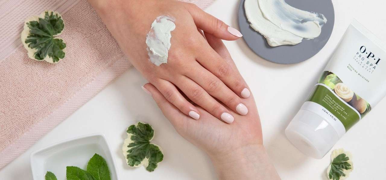 Hand receiving a manicure, OPI cream being used.