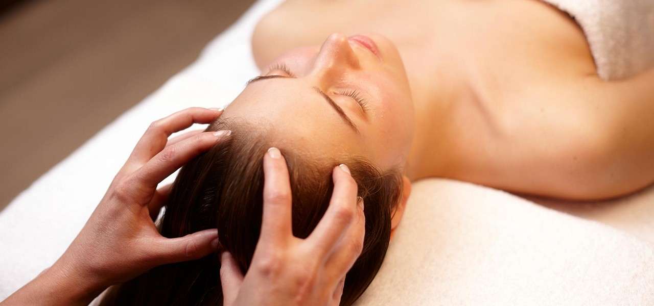 Woman laid having a head massage.