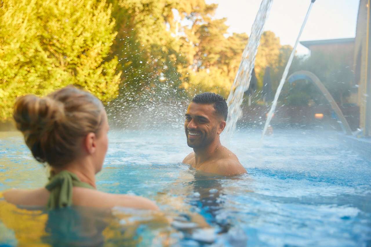 two people in outdoor pool surrounded by forest
