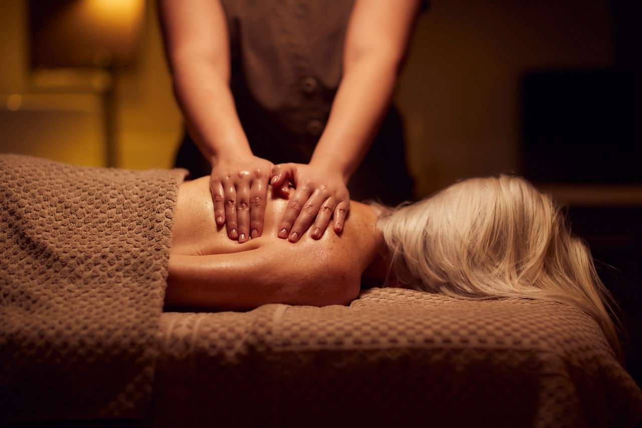 Spa therapist giving a woman a body massage treatment.