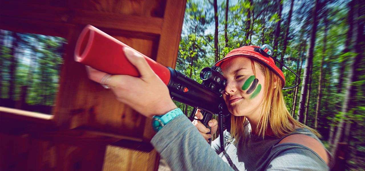 Women aiming laser combat gun wearing war paint on her face