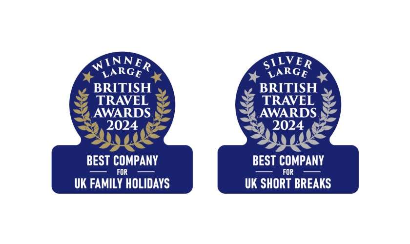 Two blue award badges display accolades against a white background: WINNER LARGE BRITISH TRAVEL AWARDS 2024 BEST COMPANY FOR UK FAMILY HOLIDAYS; SILVER LARGE BRITISH TRAVEL AWARDS 2024 BEST COMPANY FOR UK SHORT BREAKS.