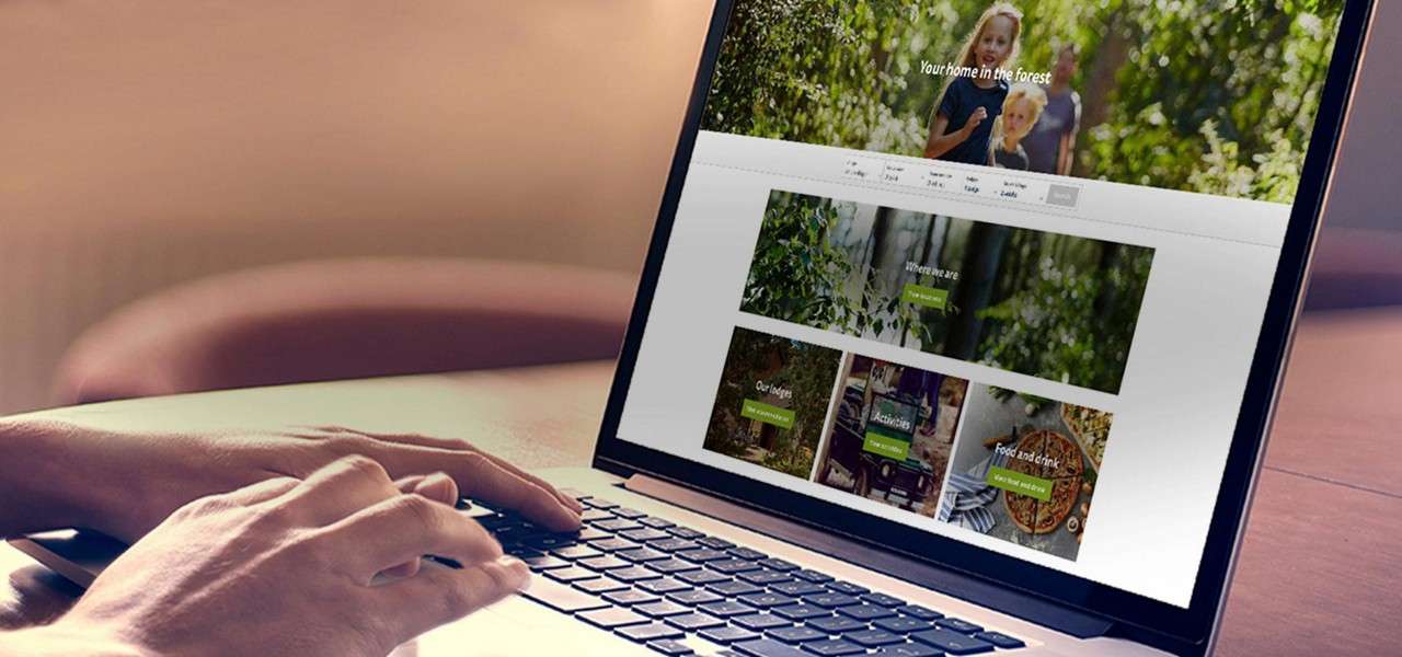 Hands type on a laptop displaying a nature-resort website at a desk.

Text: Your home in the forest. Where we are. Our lodges. Activities. Food and drink.