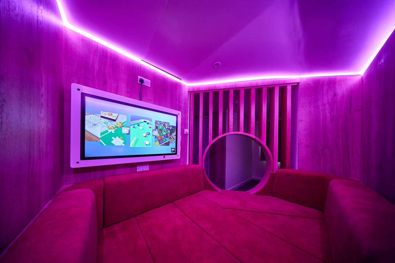 Interior shot of the snuggle pod with colourful lighting and an interactive screen.