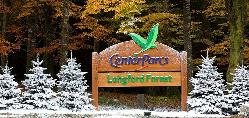Longford Forest entrance sign surrounded by snowy Christmas trees
