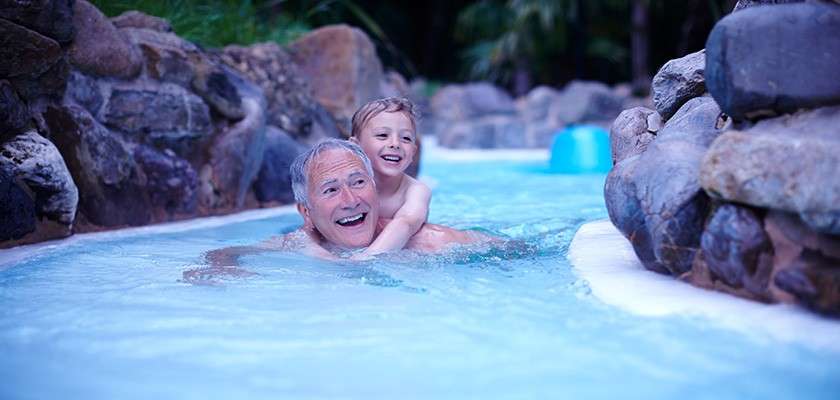 Grandfather and child going down wild water rapids.