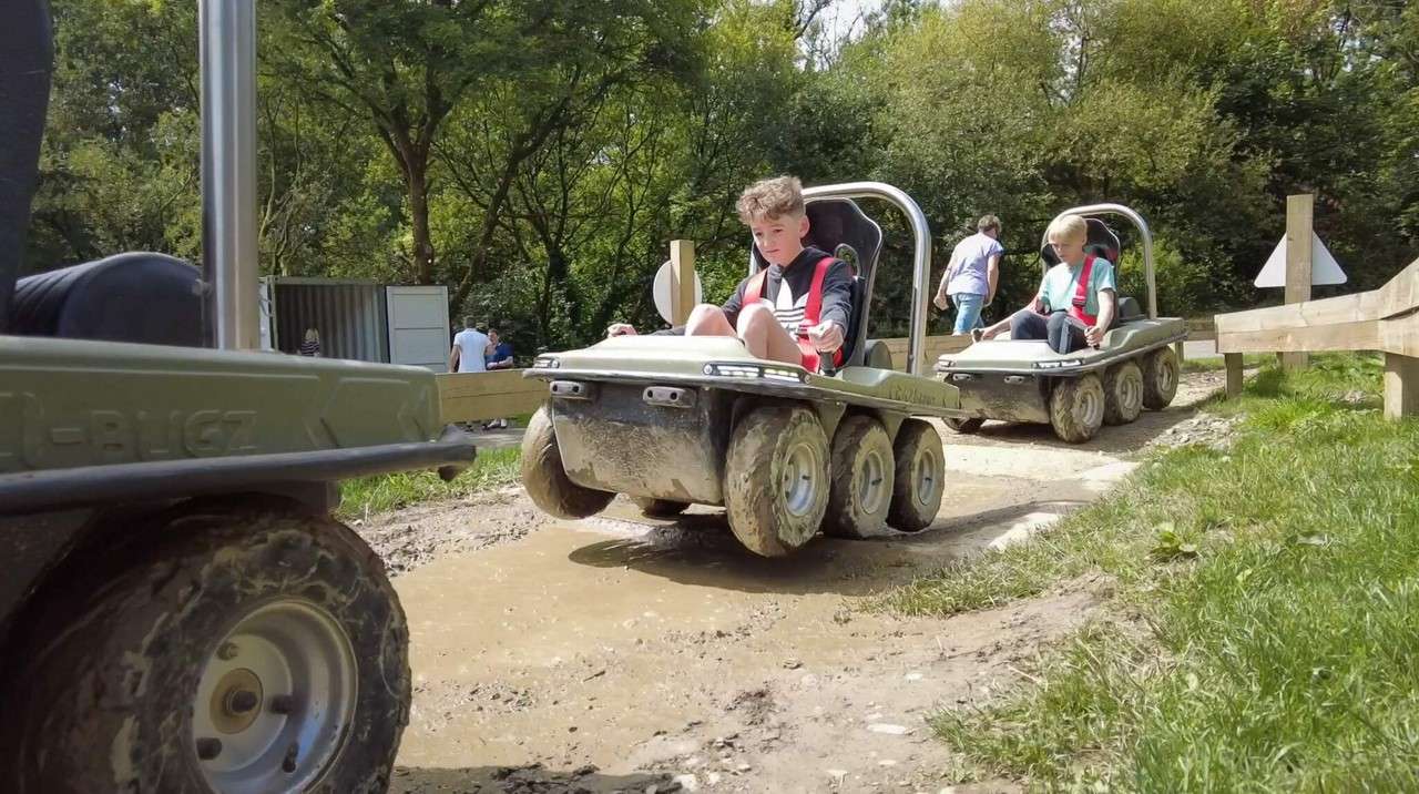Young person riding a six-wheeled electric buggy.