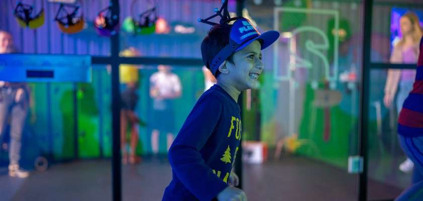 Young boy in a room of projected images.