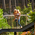 Mother holding child on a bridge looking out into the forest