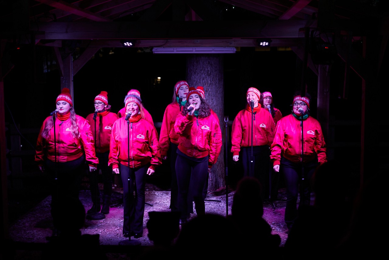 Choir singing wearing Christmas hats.