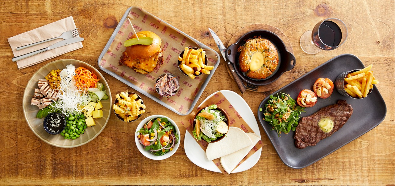 A collection of dishes from the Huck's menu, including steak, burgers and wraps.