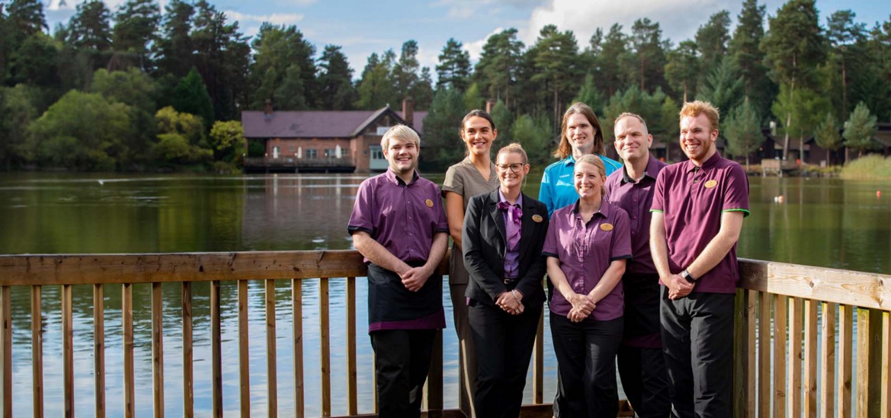 A group of staff members in front of the lake