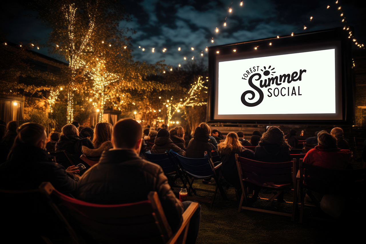 Group sitting watching a movie in an outdoor cinema experience.