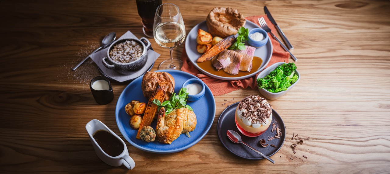 images of different foods, a glass of white wine, pot of gravy and a soft drink