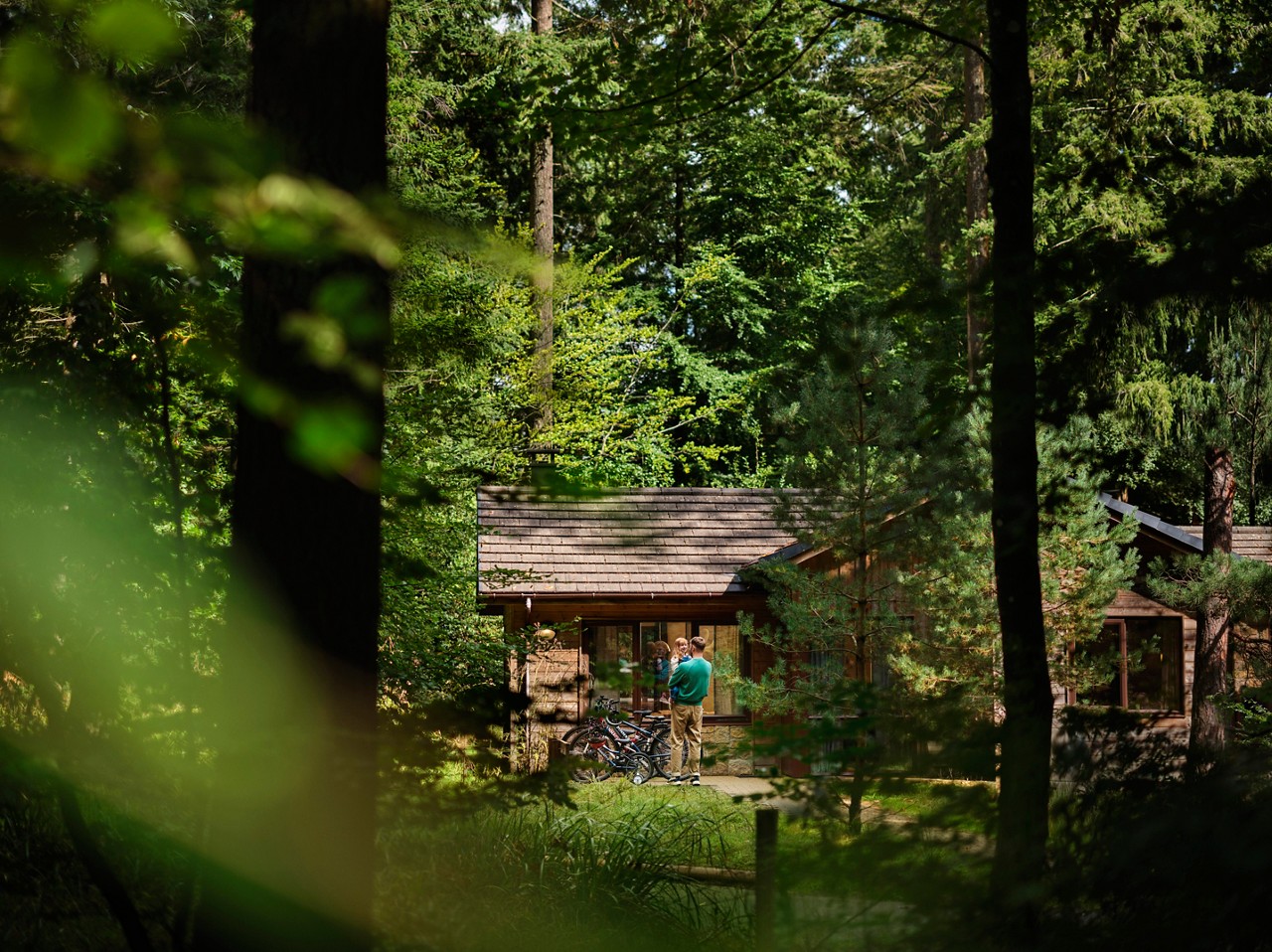 A man holding his child as he walks in to a lodge.